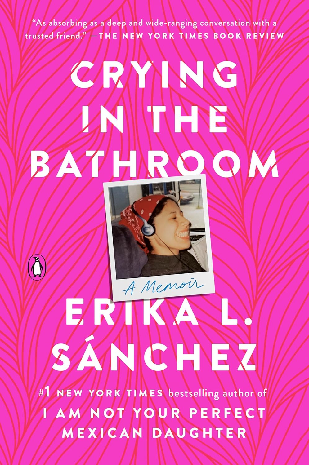The cover of Crying in the Bathroom features a pink background with leaves and includes a smiling child in headphones, reflecting the memoir-in-essays by award-winning novelist Erika L. Sánchez, about her journey as a daughter of Mexican immigrants.