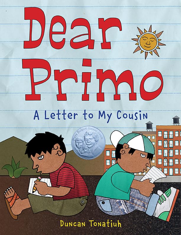 The illustrated cover of Dear Primo: A Letter to My Cousin depicts Charlie and Carlitos back-to-back writing letters among cacti and city buildings under a sun with a face, highlighting their cultural bond. The illustration features a silver medal.