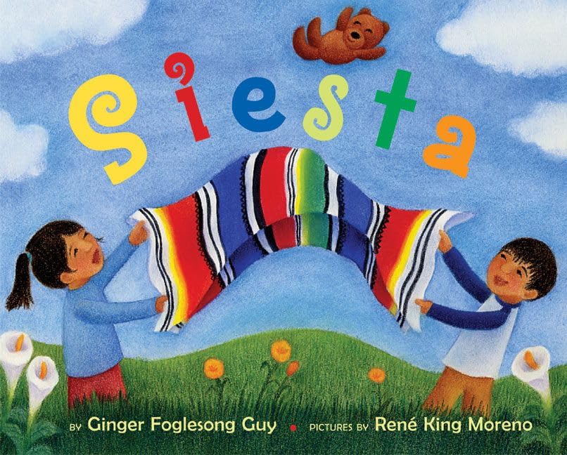 The bilingual childrens book Siesta by Ginger Foglesong Guy features an illustrated cover with two kids holding a colorful striped blanket, a teddy bear floating in a blue sky filled with fluffy clouds, and flowers blooming in the grass below.