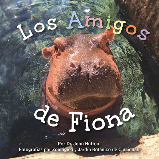 The cover of Los Amigos de Fiona features Fiona the hippo peeking from the water, highlighting Dr. John Hutton and Cincinnati Zoos dedication to raising awareness about endangered species.