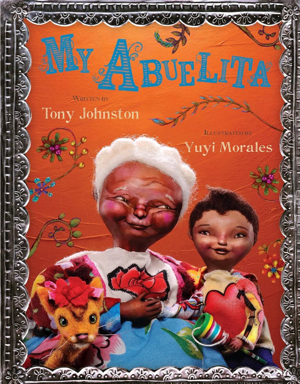 The cover of My Abuelita by Tony Johnston, illustrated by Yuyi Morales, showcases a joyful elderly storyteller with white hair alongside a child clutching a small plush toy. The orange backdrop is adorned with floral patterns, creating a festive family atmosphere.