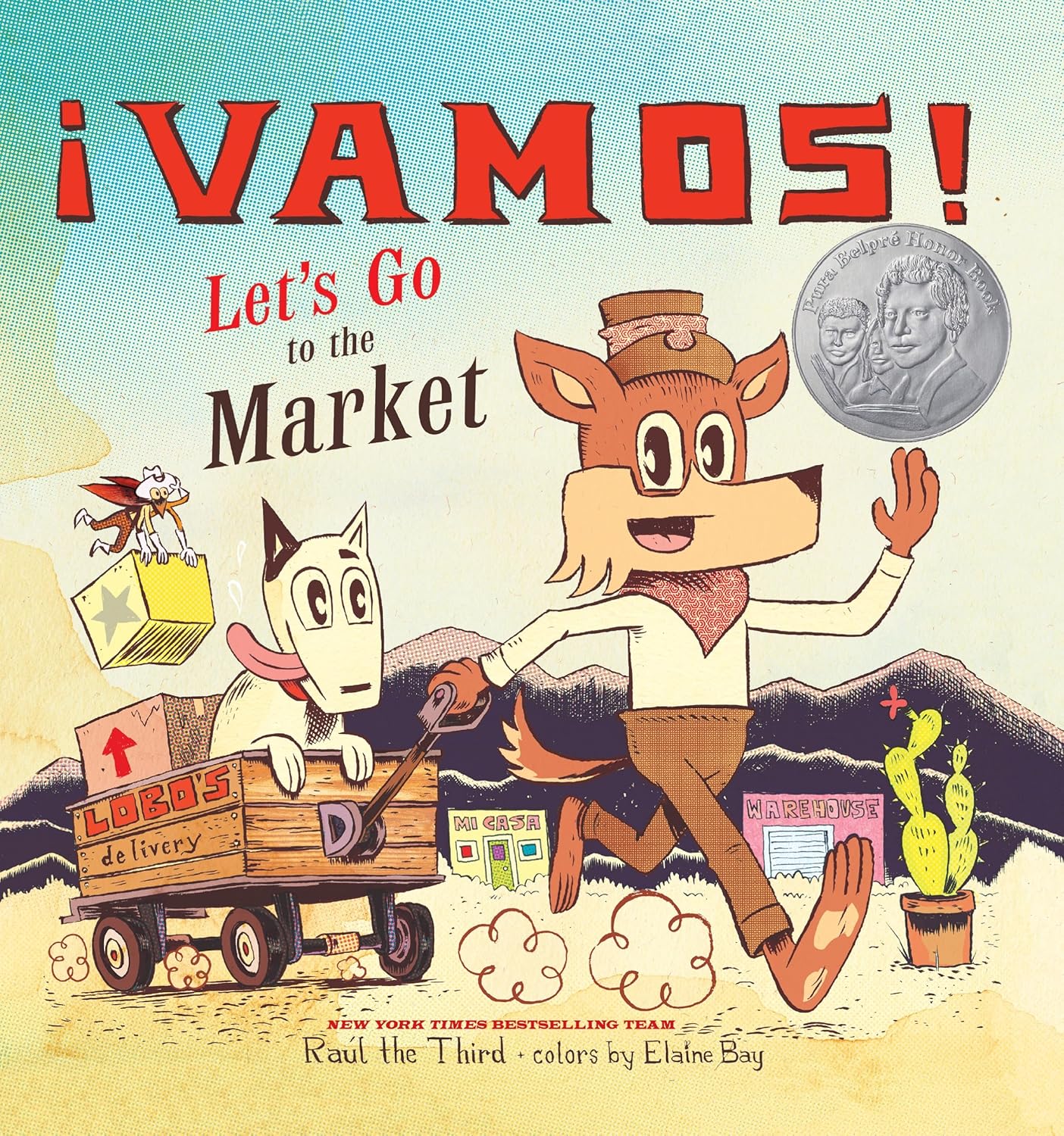 The cover of ¡Vamos! Lets Go to the Market by Raúl the Third depicts an animated wolf-like character pulling a cart with a cat, set in a lively Mexican-American border town. The scene includes market stalls, cacti, mountains, and a two-faced coin in the top right corner.